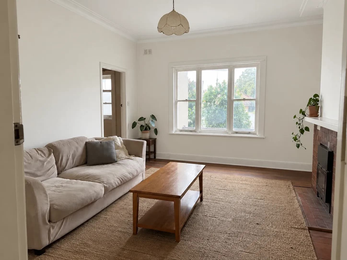 The same living room repainted in a clean warm white