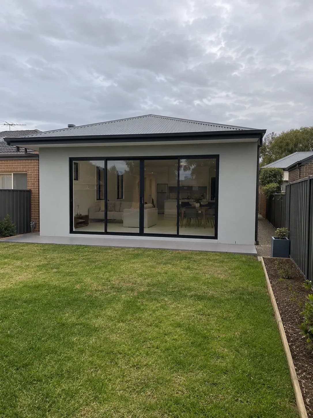Single-storey rear extension with large sliding doors opening onto a backyard